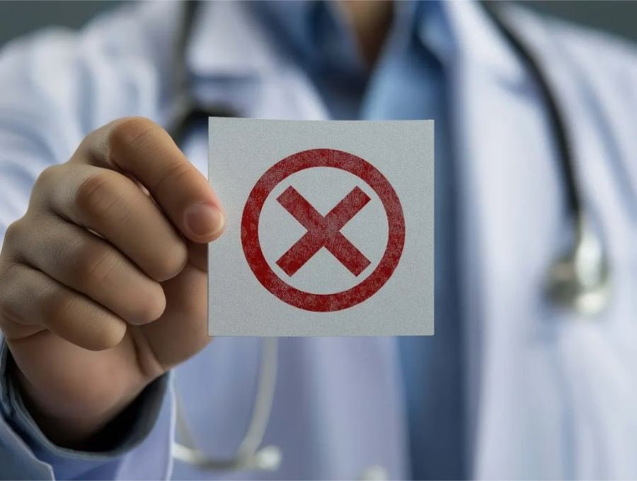 Médico segurando um cartão com um X vermelho, representando a negativa de cobertura do plano de saúde